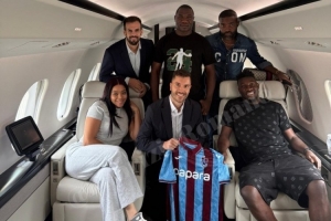 奧納納與家人、經(jīng)紀人在飛機上合影，展示特拉布宗體育球衣