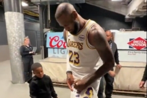 這個我也想要！小球迷拿著詹姆斯球衣 后者特意停步為他送上親簽